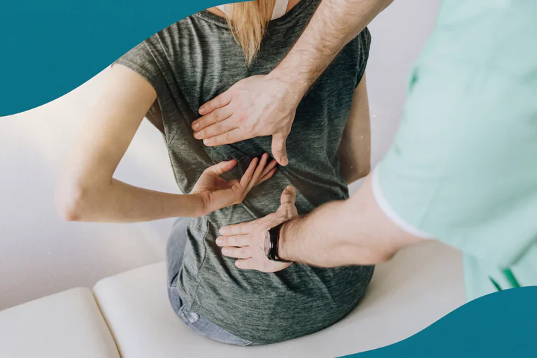 Fysioterapeut masserar en patients ländrygg.
